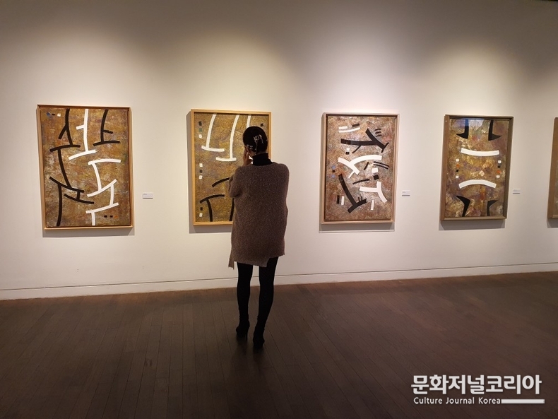 오세영 화백 심성의 기호 연작을 감상하는 관람객의 모습. 사진=에이앤씨미디어 제공