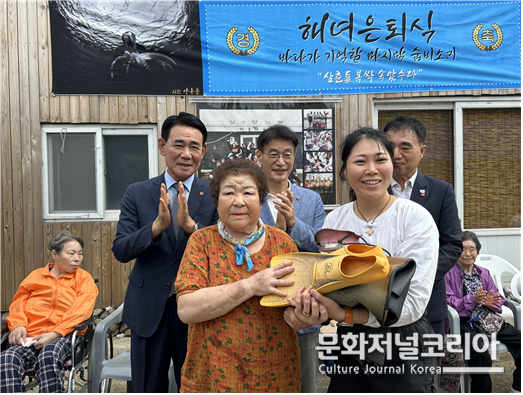 안홍자(81세) 해녀삼춘이 입었던 고무옷 일체를 이유정 새내기 해녀에게 전수하는 모습